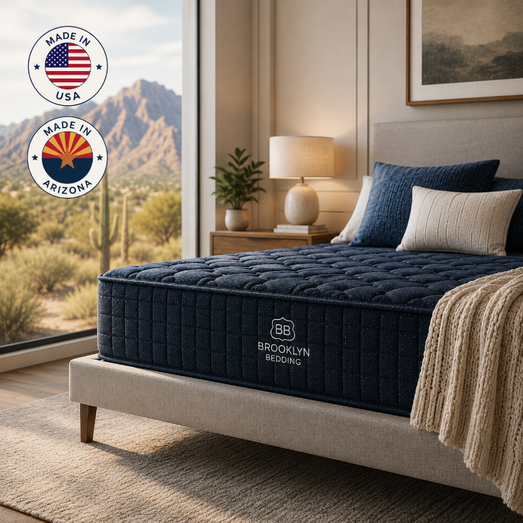 Blue mattress on a bed with 'Brooklyn Bedding' logo, desert view outside window, and 'Made in USA' and 'Made in Arizona' badges.
