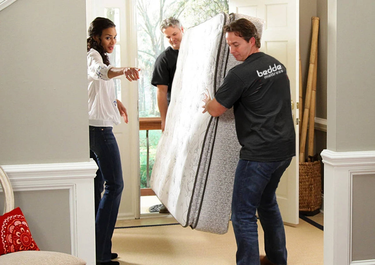 In-Home Mattress Delivery, 2 people entering home with mattress. 