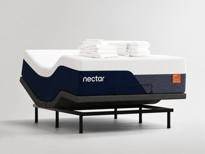 A Nectar mattress on a black metal stand, styled with folded white towels on top, set against a clean light gray studio background.