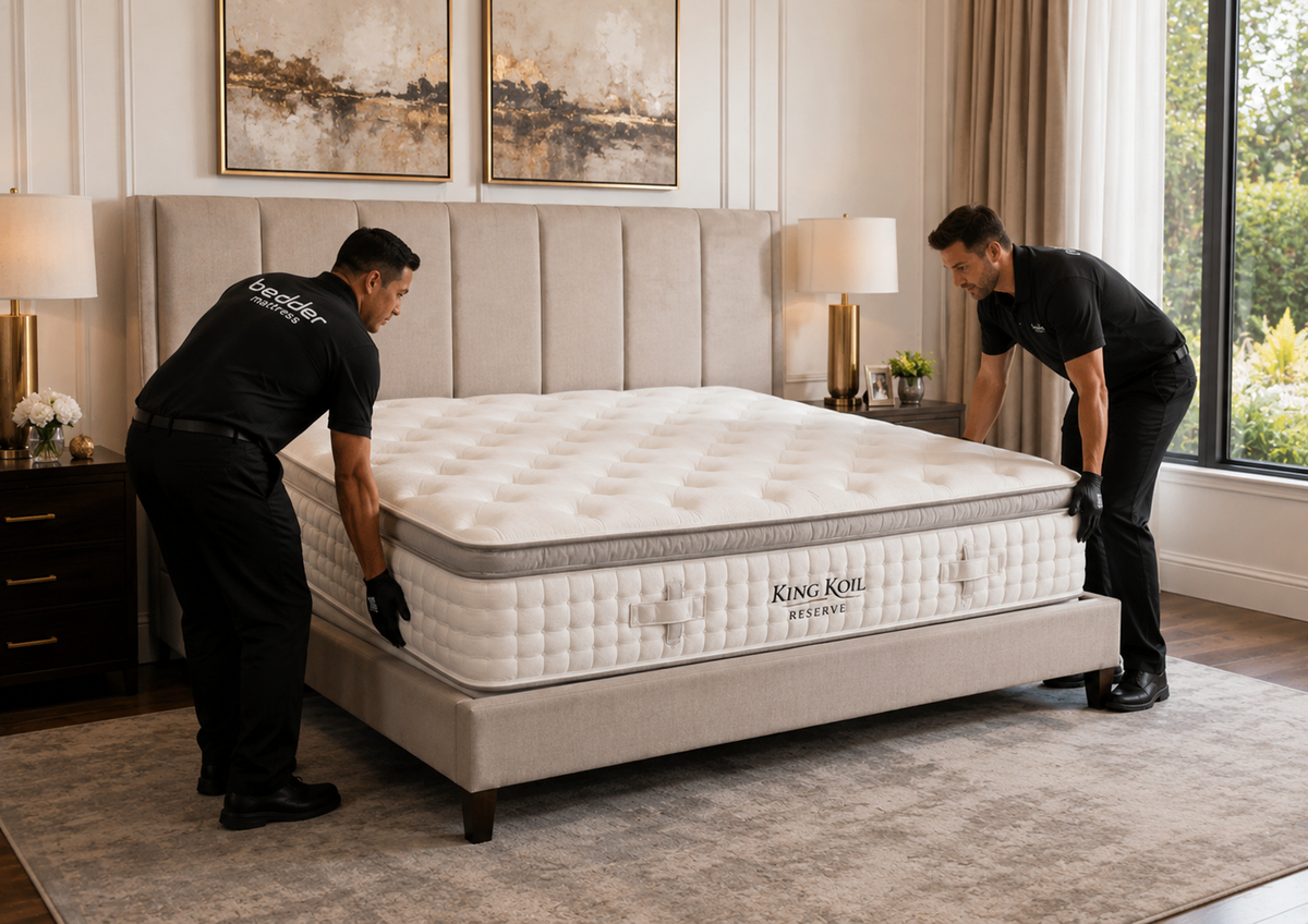 Professional Setup. The mattress already inside the bedroom with two delivery professionals carefully installing it inside a finished bed.