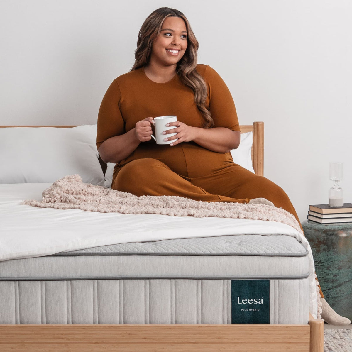 Leesa Plus Hybrid Mattress shown with a seated adult
